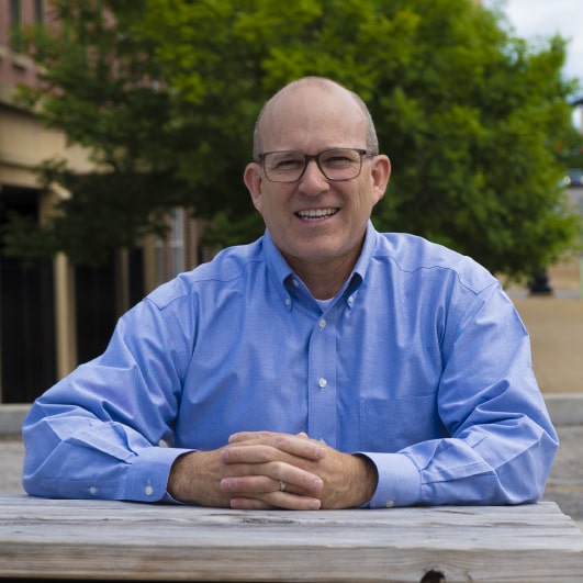 Lee Hagaman - SEM and CRO Strategy Director at the Lead Dog Digital Tyler, TX- sits at the table in front of the tree.