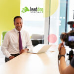 business professional sitting at desk recording a video